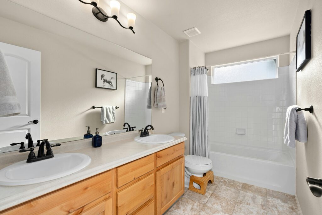 Bright and modern bathroom featuring dual sinks, a bathtub, and minimalist decor for a clean and inviting look.