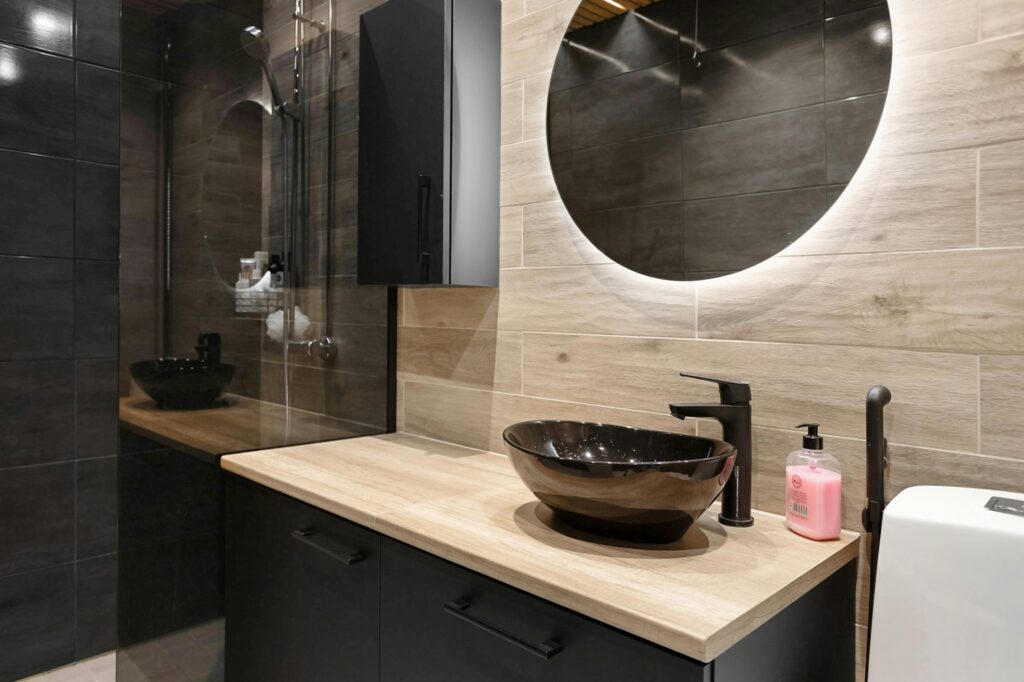 Elegant modern bathroom with stylish wooden vanity and backlit mirror, perfect for contemporary homes.
