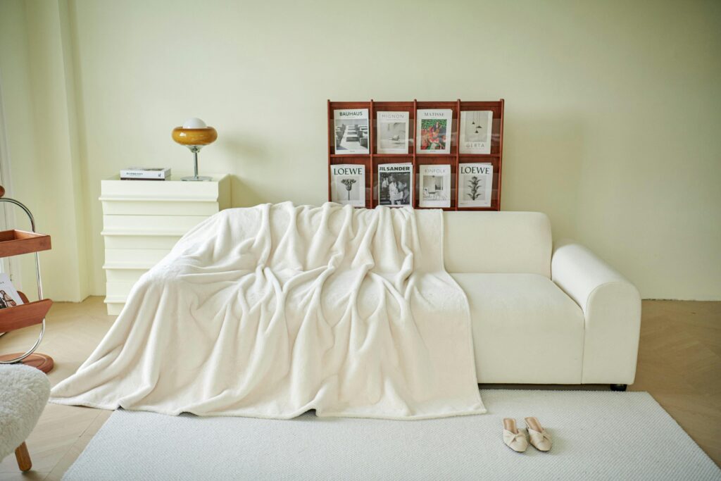 Elegant living room featuring a white sofa, throw blanket, and chic decor.