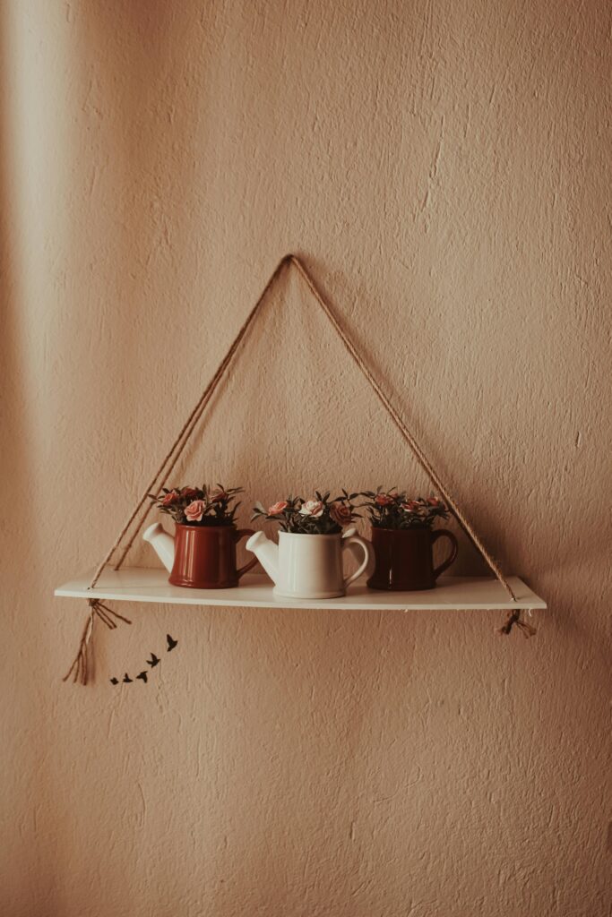 Chic hanging shelf with decorative planters enriches your indoor space with style.
