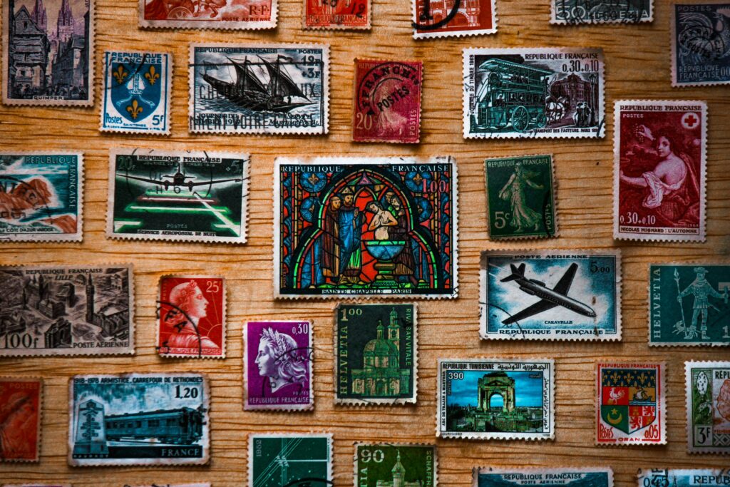 A collection of diverse vintage French postage stamps arranged on a wooden surface, showcasing history and art.