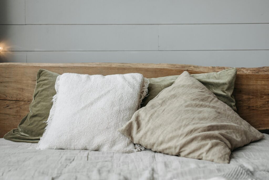 Relaxing bed setting with rustic wooden headboard and cushions.