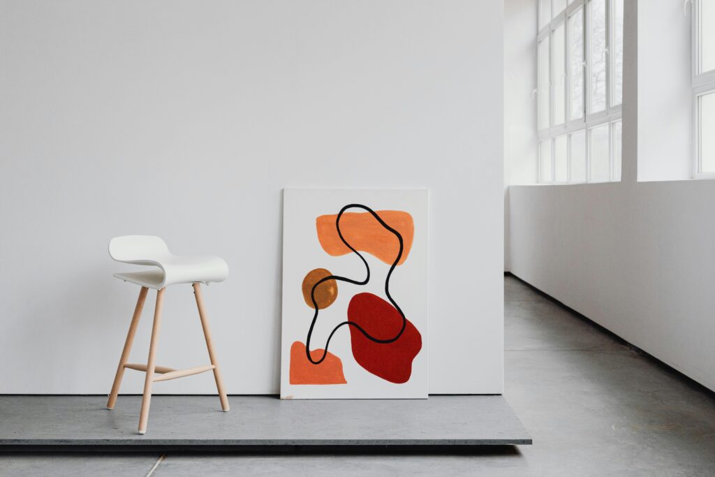Contemporary minimalist art canvas and sleek white chair in a bright modern interior.