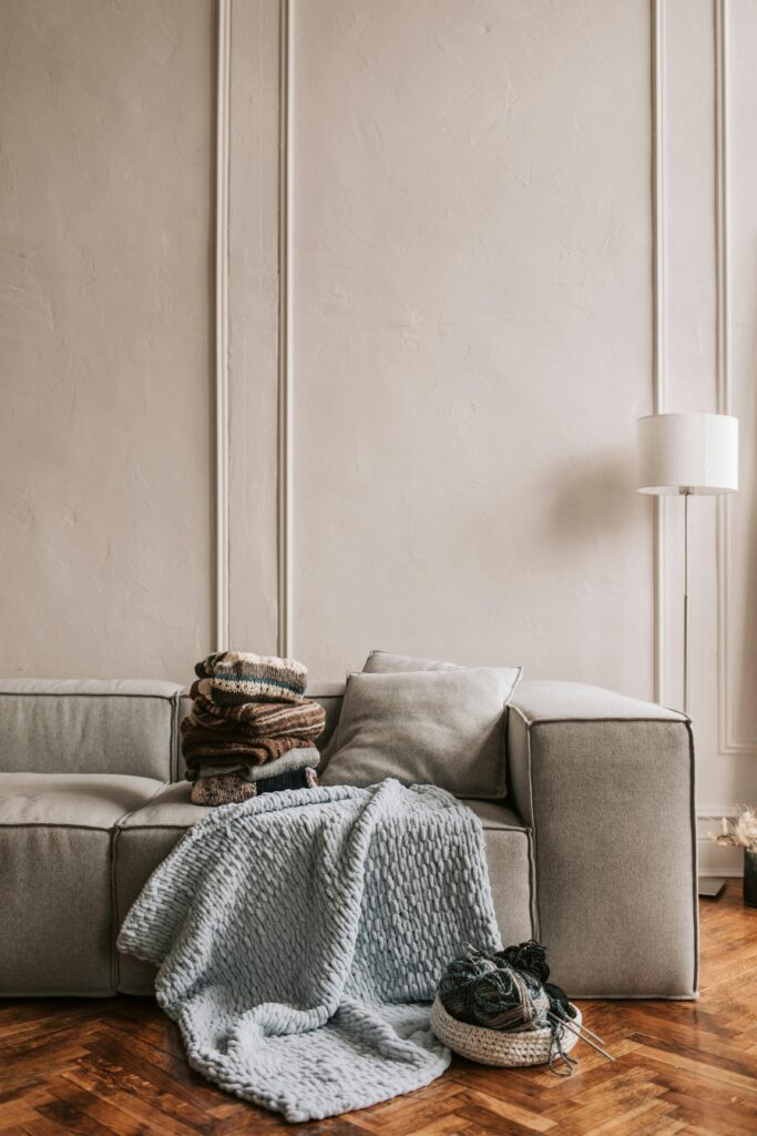 Elegant living room featuring a sofa with cozy textiles and wooden flooring.